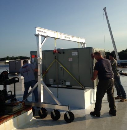 EC&MWs 2TAC1212 Model air tire gantry crane. Worker are moving a roof top air handler